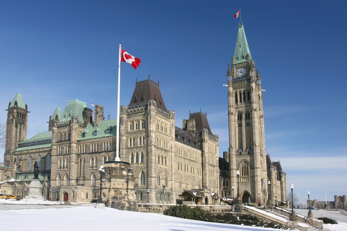 Centre Block and Peace Tower on Parliament Hill in Ottawa with the Canadian flag.